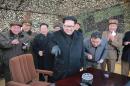 This undated picture released from North Korea's official Korean Central News Agency on March 4, 2016 shows North Korean leader Kim Jong-Un (C) inspecting a test-fire of the new-type large-caliber multiple launch rocket system