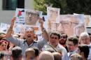 Relatives and activists hold pictures of Jordanian writer Nahed Hattar, who was shot dead, and shout slogans during a sit-in in front of the prime minister's building in Amman