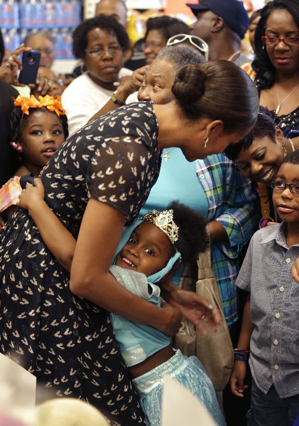 First lady Michelle Obama hugs Naomi Bouie, 5, during her visit to Sterling Farms Grocery Store in Marrero, La., Tuesday, July 23, 2013. The store was opened last year by actor Wendell Pierce as part of the "Alliance For A Healthier Generation," Earlier she spoke about childhood obesity at the annual meeting of the National Council of La Raza. (AP Photo/Gerald Herbert)