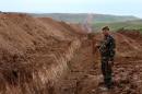 A member of Iraqi security forces looks on during the digging operations to build a trench on the northern Iraqi border with Syria to prevent people from crossing over into Iraq's autonomous Kurdistan region, on April 13, 2014 in Zakho