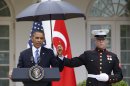 President Barack Obama speaks under an umbrella held by a Marine as a light rain falls during a news conference with Turkish Prime Minister Recep Tayyip Erdogan, Thursday, May 16, 2013, in the Rose Garden of the White House. (AP Photo/Jacquelyn Martin)