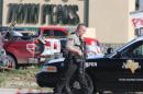 FILE - In this May 17, 2015 file photo, authorities investigate a shooting in the parking lot of the Twin Peaks restaurant, in Waco, Texas. Bikers and public watchdogs have criticized authorities here for how they've handled the shooting investigation, citing the mass arrests of more than 170 people held for days or weeks on $1 million bonds without sufficient evidence to support those arrests four months after the shootings. No formal charges have been made, and it remains unclear whose bullets, including police bullets, struck the dead and injured, or when cases will be presented to a grand jury, which is currently led by a Waco police detective. (AP Photo/Jerry Larson, File)