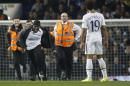 Tottenham's Mousa Dembele watches as stewards try to catch a pitch invader during the Europa League group C soccer match between Tottenham Hotspur and Partizan Belgrade at White Hart Lane stadium in London, Thursday, Nov. 27, 2014 .(AP Photo/Alastair Grant)