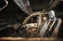 Security officials collect evidence near a damaged vehicle at the site of a suicide bomb attack in Peshawar