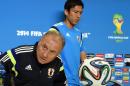 Japan's Italian coach Alberto Zaccheroni (L) and Japan's captain and midfielder Makoto Hasebe (R) take their seats to start their team's official press conference at the Dunas Arena in Natal on June 18, 2014