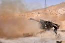 A Syrian soldier fires artillery shells towards Islamic State group jihadists in northeastern Palmyra, on May 17, 2015