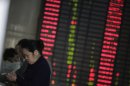 Investors check the stock price at a private securities company in Shanghai, China on Tuesday Nov. 13, 2012. Asian stock markets fell Tuesday, after Europe's finance ministers postponed approval of an urgently needed aid payment for debt-mired Greece. (AP Photo/Eugene Hoshiko)
