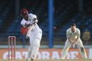 West Indies opening batsman Kraigg Brathwaite, left, hits a shot that is caught by New Zealand bowler Trent Boult for 129 runs during the second day of their second cricket Test match in Port of Spain, Trinidad, Tuesday, June 17, 2014. (AP Photo/Arnulfo Franco)