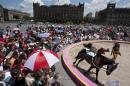 A circus performer dressed in native American garb leaps on and off a running horse, during a free public show to protest Mexico City's ban on circus animals in Mexico City's main square, the Zocalo, Tuesday, July 22, 2014. Mexico's "circus wars" are heating up, with a growing movement to ban circus animals, other than horses and dogs, meeting rising anger from circus workers. Circuses say threats of violence against them have been posted online. (AP Photo/Rebecca Blackwell)