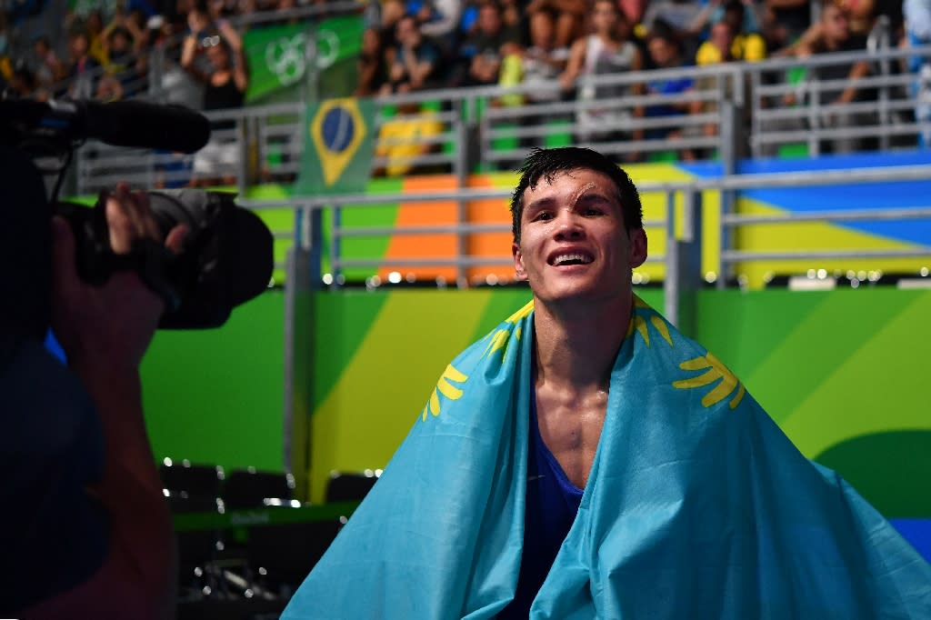 Kazakhstan's Daniyar Yeleussinov holds his country's national flag as he celebrates winning against Uzbekistan's Shakhram Giyasov during the Men's Welter (69kg) Final Bout match at the Rio 2016 Olympic Games on August 17, 2016 (AFP Photo/Yuri Cortez)