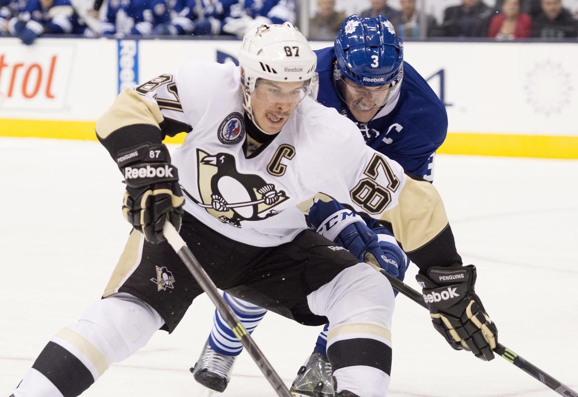 Pittsburgh Penguins' Sidney Crosby, left, and Toronto Maple Leafs' Dion Phaneuf fight for position during the third period of NHL hockey action in Toronto on Friday, Nov. 14, 2014