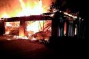 In this photo provided by the Hillsborough County Sheriff's Office, flames destroy a home in a gated community Wednesday May 7, 2014 in Tampa, Fla. Officials have confirmed that three bodies have been found in the home. (AP Photo/Hillsborough County Sheriff's Office)