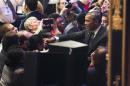 U.S. President Barack Obama is reflected in a mirror as he shakes hands with activists in Washington