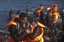 A man hugs his spouse after travelling by boat to a beach on the northern shore of Lesbos, Greece, Saturday, Nov. 7, 2015. Well over half a million people have reached the Greek islands so far this year, a record number of arrivals, and the journey has proved fatal for hundreds. (AP Photo/Marko Drobnjakovic)