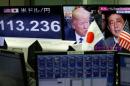 A TV monitor showing U.S. President Donald Trump and Japanese Prime Minister Shinzo Abe is seen next to another monitor showing the Japanese yen's exchange rate against the U.S. dollar at a foreign exchange trading company in Tokyo