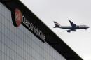 A British Airways airplane flies past a signage for pharmaceutical giant GlaxoSmithKlein in London