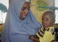 In this photo released by the International Rescue Committee, Minhaj Gedi Farah is held in the arms of his mother Asiah Dagane in the International Rescue Committee (IRC) hospital in Dadaab, Kenya Wednesday, Oct. 19, 2011. In July, Minhaj was one of dozens of limp babies under mosquito net shrouds in the sweltering wards of the IRC hospital in Dadaab, the world's largest refugee camp, but after months of intensive feeding the Somali boy has the chubby cheeks and cheeky smile of most babies his age. (AP Photo/IRC) EDITORIAL USE ONLY