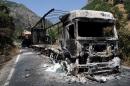 Two burnt trucks reportedly set on fire by Kurdistan Workers' Party (PKK) militants stand in Tunceli, eastern Turkey, on August 2, 2015