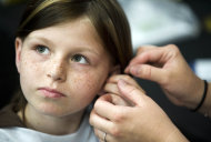 FILE -This May 2010 file photo shows Zahra Clare Baker, 10, getting a hearing aid during an event at Charlotte Motor Speedway in Hickory, N.C. Elisa Baker , stepmother of Zahra Clare Baker, was indicted Monday, Feb. 21, 2011 on a second-degree murder charge in Zahra Clare Baker's death. Elisa Baker had previously been charged with obstructing justice in the investigation of Zahra Baker's death. The 10-year-old was reported missing in October, and police later found her remains in different locations in western North Carolina.