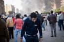 A man struggles to breath after inhaling tear gas fumes during clashes between supporters of ousted president Mohamed Morsi and security forces in Cairo on January 8, 2014