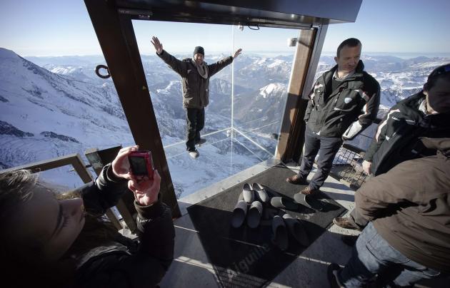 Journalists and employees visit the &#39;Step into the Void&#39; installation as they attend a press visit at the Aiguille du Midi mountain peak above Chamonix, in the French Alps