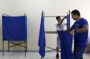 Men prepare voting booths ahead of the referendum at a high school, which will be used a polling station in Athens