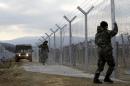 FILE - In this February 8, 2016 file photo, Macedonian Army soldiers erect a second fence on the border line with Greece, near the southern Macedonia's town of Gevgelija. Six nations from Central and Eastern Europe meet Monday in Prague to discuss plans for a new 