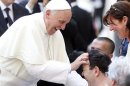 Pope Francis blesses a sick man after a mass in Saint Peter's Square at the Vatican