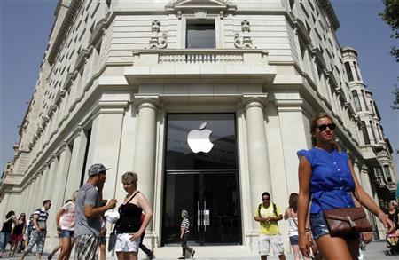 People walk past a closed shop, which will be opened and inaugurated as the largest Apple store in southern Europe