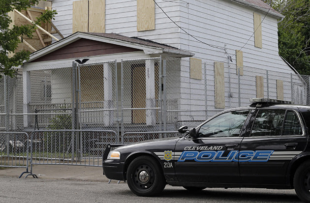 A patrol car in front of Ariel Castro's boarded-up home in Cleveland. (Mark Duncan/AP)