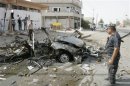 Security personnel inspect the site of a car bomb attack in Kirkuk