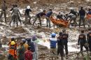 Rescuers remove the body of a victim of landslides that swept away houses in Jemblung village, Central Java, Indonesia, Saturday, Dec. 13, 2014. Scores of people died and more than 100 are missing following landslides caused by heavy rain in central Indonesia on Friday, local government officials said Saturday. (AP Photo/Bayu Nur)