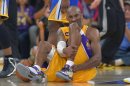 El escolta Kobe Bryant de los Lakers de Los Angeles hace un gesto de dolor tras lesionarse durante un partido frente a los Warriors de Golden State, el viernes 12 de abril de 2013, en Los Angeles. (Foto AP/Mark J. Terrill)