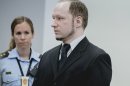 Anders Behring Breivik, who has admitted to the July 22, 2011 massacre and a bombing in Oslo that killed eight people earlier that day, stands with a police woman in court in Oslo Thursday May 10, 2012. (AP Photo/Krister Sorbo/NTB Scanpix, Pool)