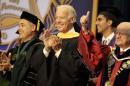 Vice President Joe Biden, center, smiles after arriving for a graduation ceremony at the Miami Dade College in Miami, Saturday, May 3,2014. Biden said a "constant, substantial stream of immigrants" is important to the American economy, urging citizenship for immigrants living in the U.S. illegally. (AP Photo/Javier Galeano)