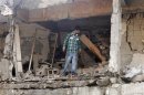 A man walks among the ruins of a damaged building at the site of a blast in the town of Reyhanli