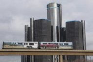 Two cars of the 'people mover' public rail are seen covered with a advertisement for the 2014 Chevy Silverado pickup truck as they move past General Motors World Headquarters in Detroit, Michigan January 11, 2013. REUTERS/Rebecca Cook