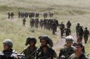 Israeli soldiers walk together during training close to the ceasefire line between Israel and Syria on the Golan Heights