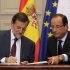 Spain's Prime Minister Mariano Rajoy, left, and French President Francois Hollande, sign cooperation agreements during a Franco-Spanish summit at the Elysee Palace, in Paris,  Wednesday, Oct. 10, 2012. (AP Photo/Philippe Wojazer, Pool)