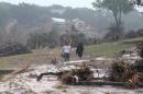 Hudson Doty, 18, left, and Grant Guzal, 17, right, walk along the bank of the Blanco River near the foundation and stilts of the Carey family home on Deer Crossing Lane, in Wimberley, Texas, on Monday, May 25, 2015. The Carey family and McComb family, from Corpus Christi, Texas, have been missing since after their home was swept away by the Blanco River early Sunday morning. (Rodolfo Gonzalez/Austin American-Statesman via AP)