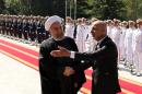 Iran's President Hassan Rouhani shakes hands with Afghan President Mohammad Ashraf Ghani (R) during an official welcoming ceremony following the latter's arrival at the Saadabad Palace in Tehran on April 19, 2015