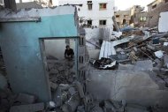 Israel bombardeó objetivos milicianos palestinos en la Franja de Gaza el domingo por quinto día consecutivo, preparándose para una posible invasión terrestre mientras desgranaba sus condiciones para una tregua. En la imagen, un palestino se sienta sobre los escombros de una casa destruida en la Franja de Gaza, el 18 de noviembre de 2012. REUTERS/Mohammed Salem