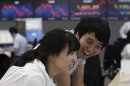 Currency traders smile at the foreign exchange dealing room of the Korea Exchange Bank headquarters in Seoul, South Korea, Tuesday, July 31, 2012. The Korea Composite Stock Price Index rose 2.27 percent, or 38.20, to close at 1,881.99. (AP Photo/Ahn Young-joon)