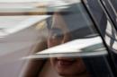 Myanmar's State Counsellor Aung San Suu Kyi sits in her car after arriving at the airport in New Delhi