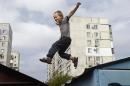 Sacha, 6 years old, jumps on metal rooftops in the outskirts of the southeastern port city of Mariupol on September 8, 2014