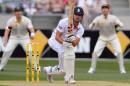 England captain Alastair Cook (C) drives a ball as Australian players Shane Watson (L) and Michael Clarke (R) look on on the first day of the fourth Ashes cricket Test played at the Melbourne Cricket Ground (MCG), in Melbourne on December 26, 2013