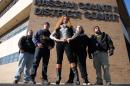 Michelle Esquenazi (C), known as The Bail Bond Queen, poses with her agents and bodyguards in front of the Nassau County courthouse in Hempstead, New York