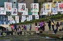 Visitors take pictures beneath campaign posters of South Korean general election candidates displayed at Cheonggye stream in Seoul on April 11, 2016