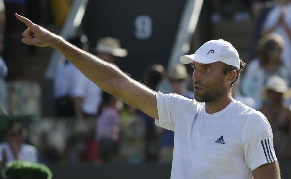 The Latest: Karlovic has to defend double-hit at Wimbledon