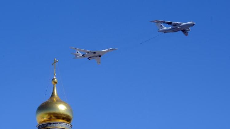 A Russian Il-78 aerial refueling tanker (right) and Tu-160 supersonic strategic bomber (left) fly over the Kremlin cathedral during a rehearsal of the Victory Day parade in Moscow on May 7, 2013